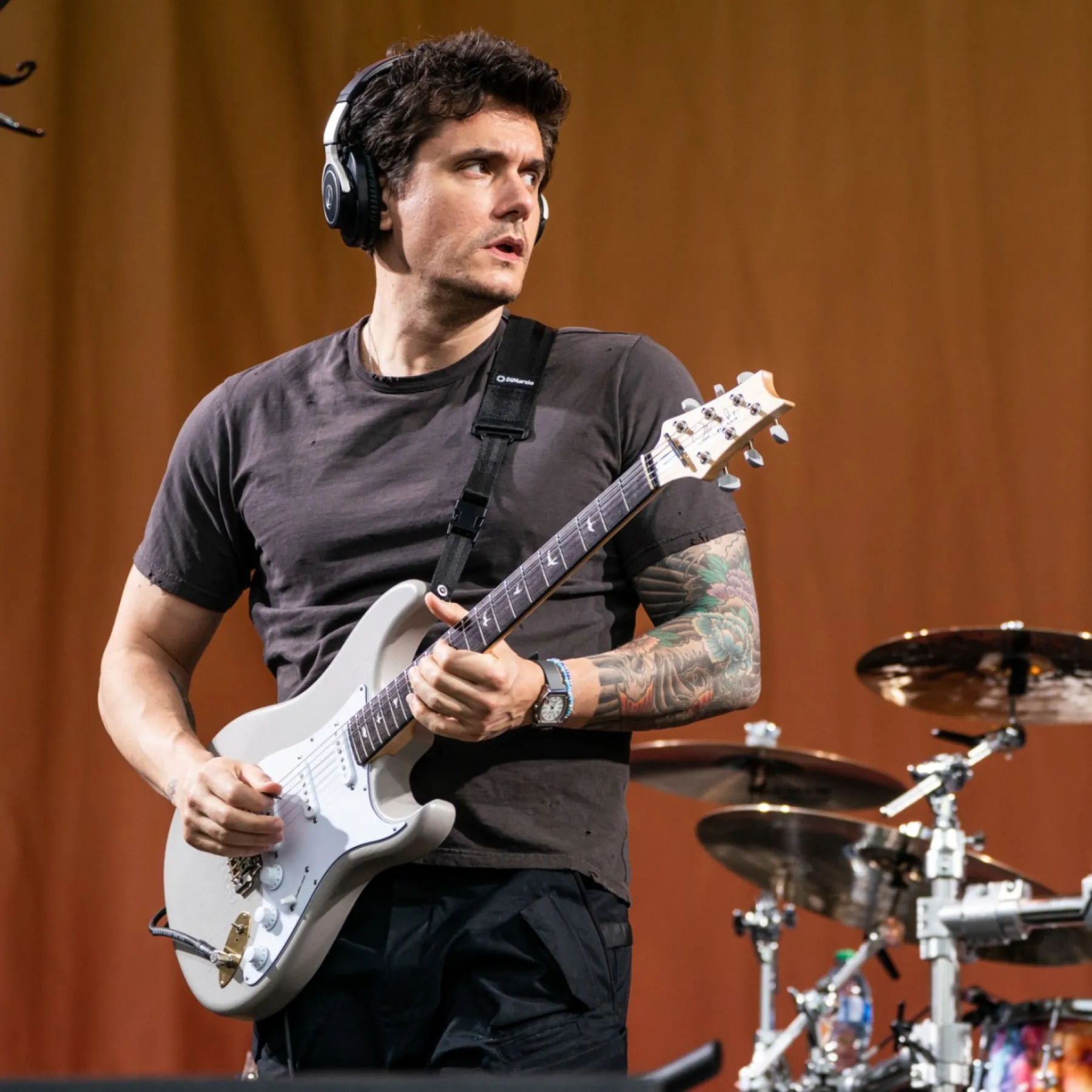 John Mayer playing guitar on stage